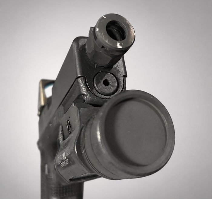 Flashlight lens with heavy carbon fouling from live fire